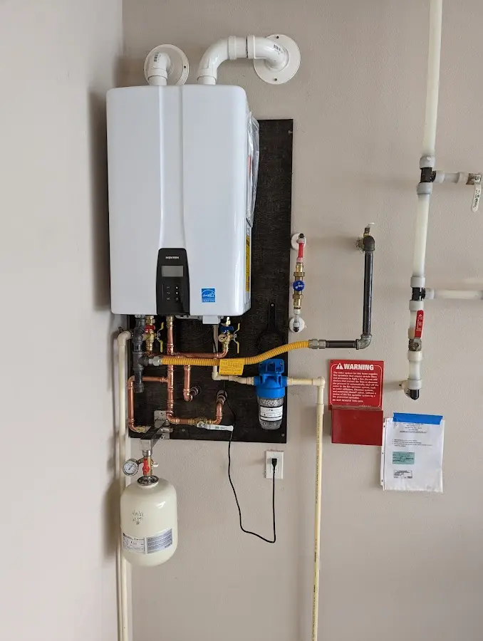 Professional plumber installing copper piping in a Carlyle home